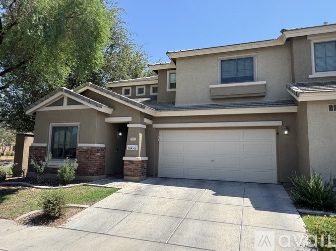 A two-story house with a garage and a driveway.
