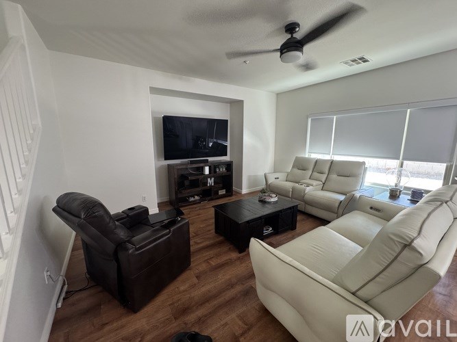 A living room with a black leather chair and a white leather sofa.