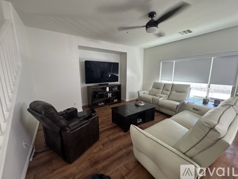 A living room with a black leather chair and a white leather sofa.