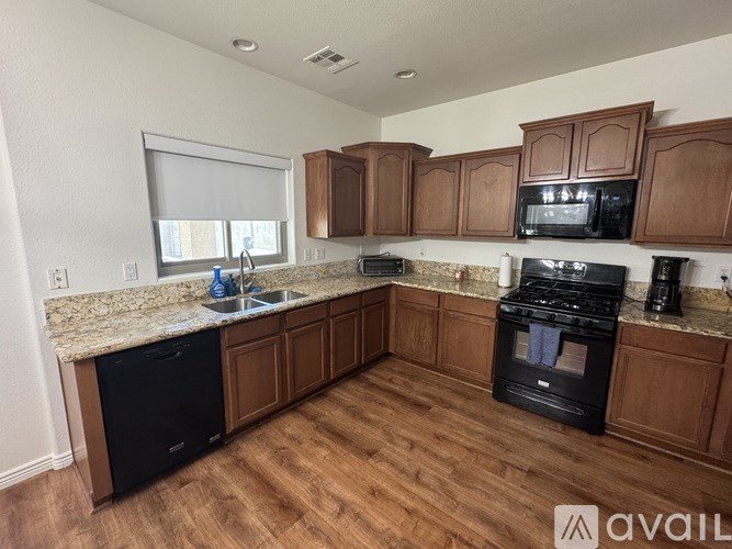 A kitchen with wooden cabinets and black appliances.