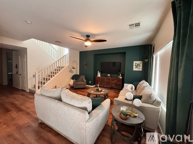 A bathroom with a white sink, toilet, and a mirror with lights above it.