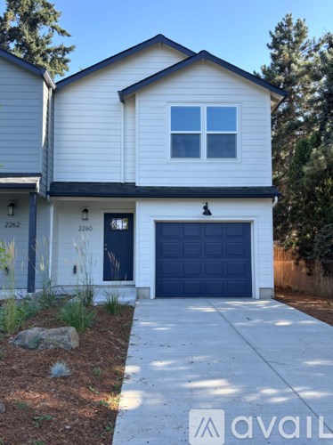 A two-story house with a garage door and a driveway.