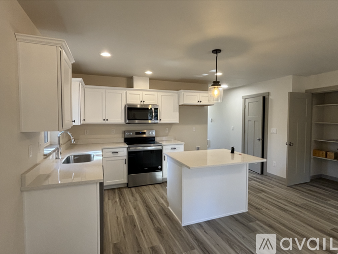 A modern kitchen with white cabinets and a central island.
