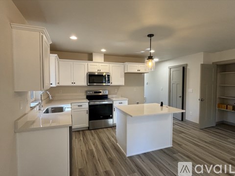 A modern kitchen with white cabinets and a central island.