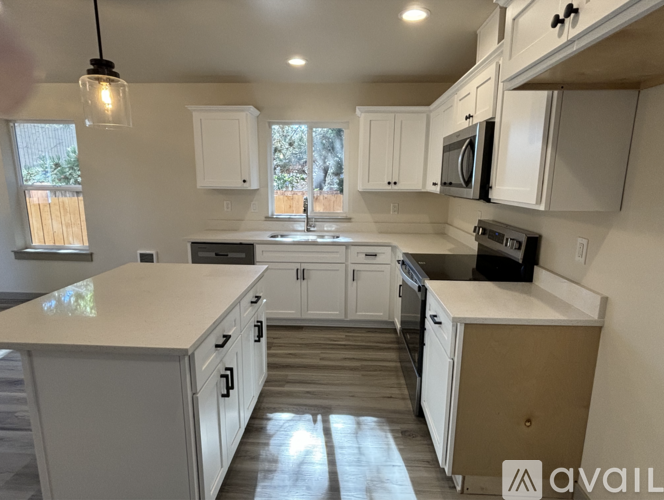 A kitchen with white cabinets and a large island.