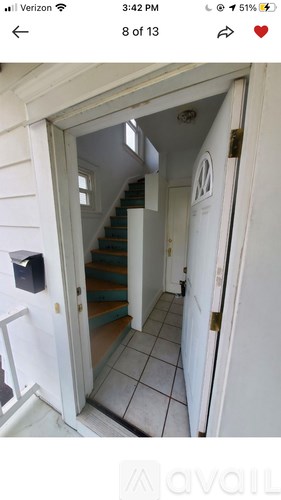 A hallway with a staircase and a white door.