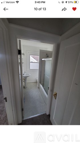 A bathroom with a toilet, sink and mirror.
