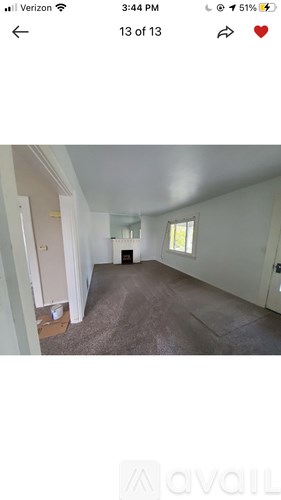 A room with a carpeted floor and a door on the left.