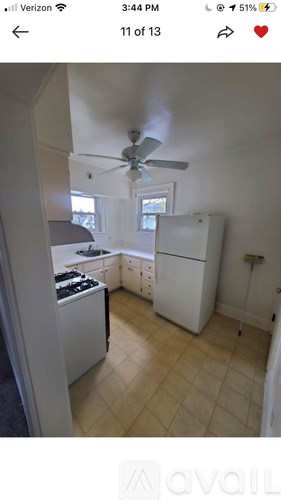 A kitchen with a fan and a fridge.
