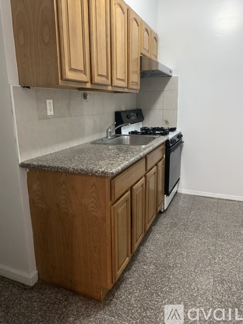 A kitchen with wooden cabinets and a granite countertop.