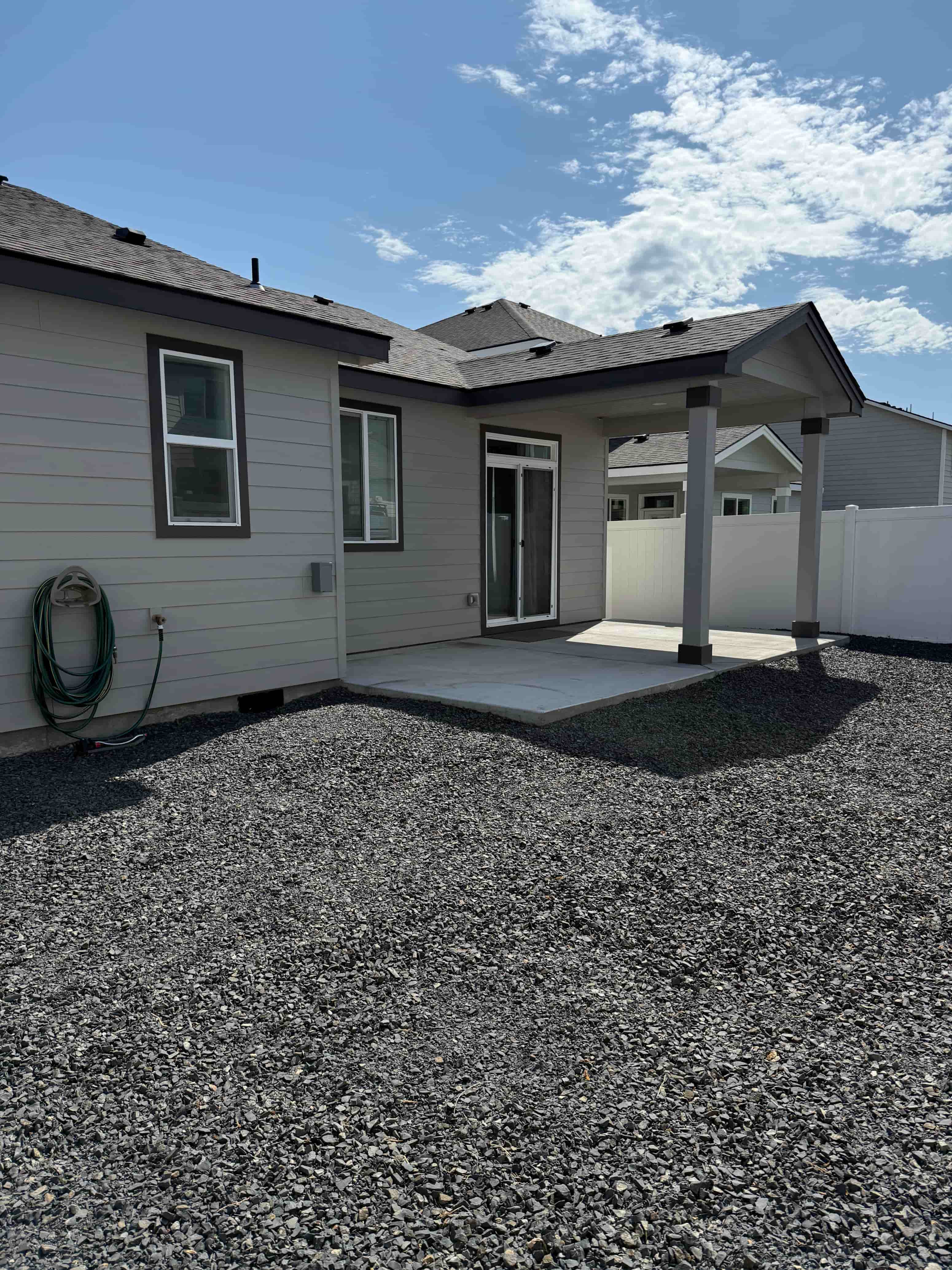 A house with a grey roof and a covered patio.