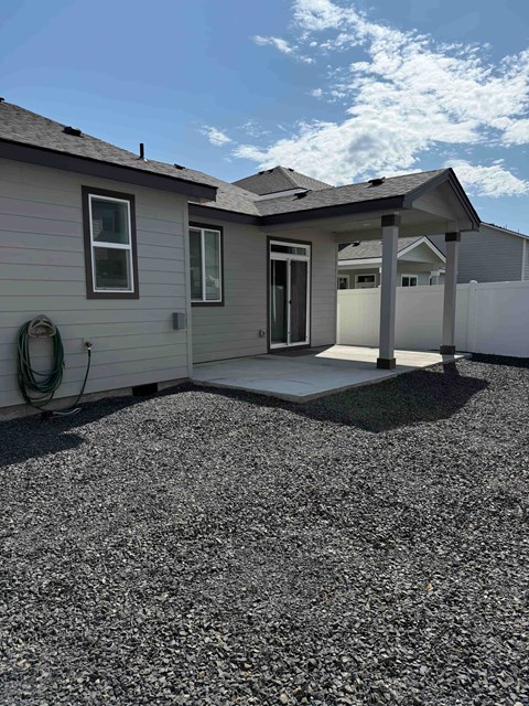 A house with a grey roof and a covered patio.