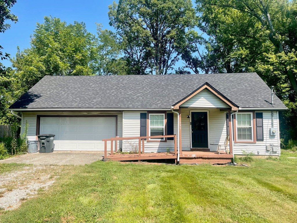 A small house with a grey garage door and a black front door.