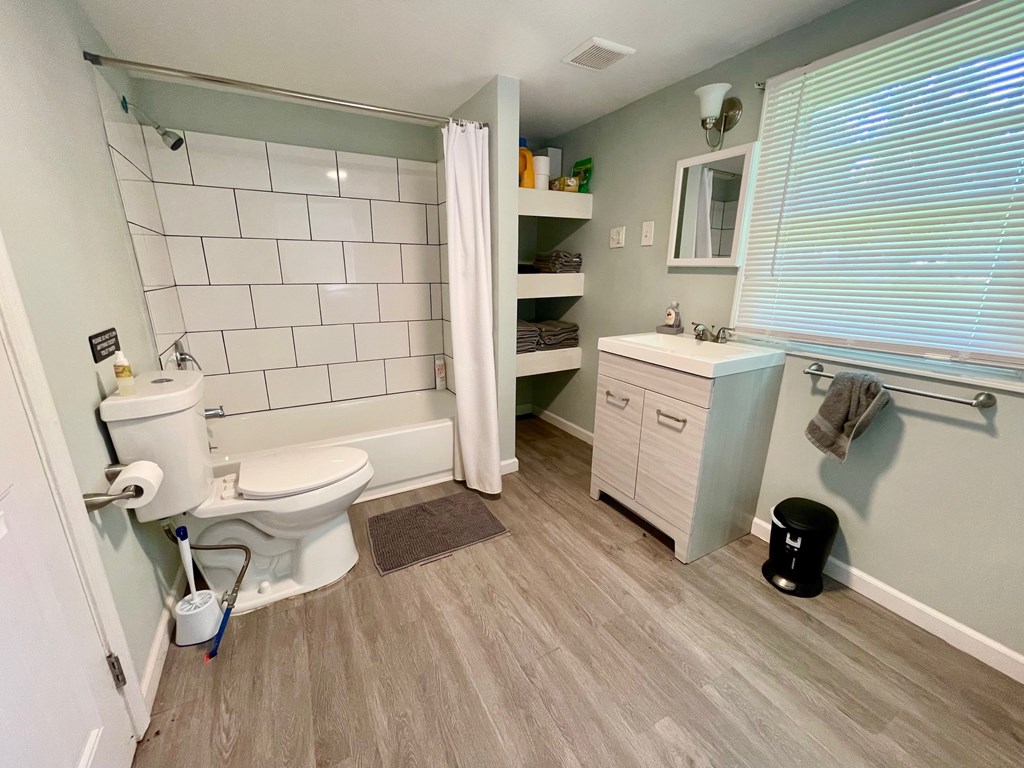 A bathroom with a toilet, sink, and shower.