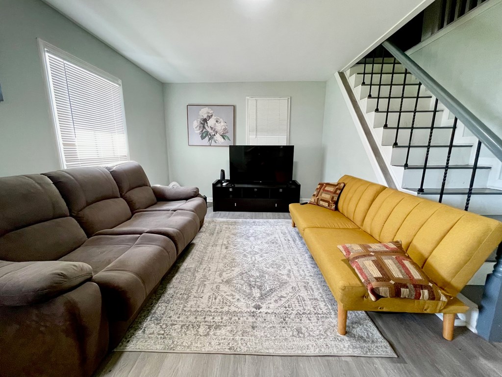 A living room with a brown leather sofa and a yellow sofa.