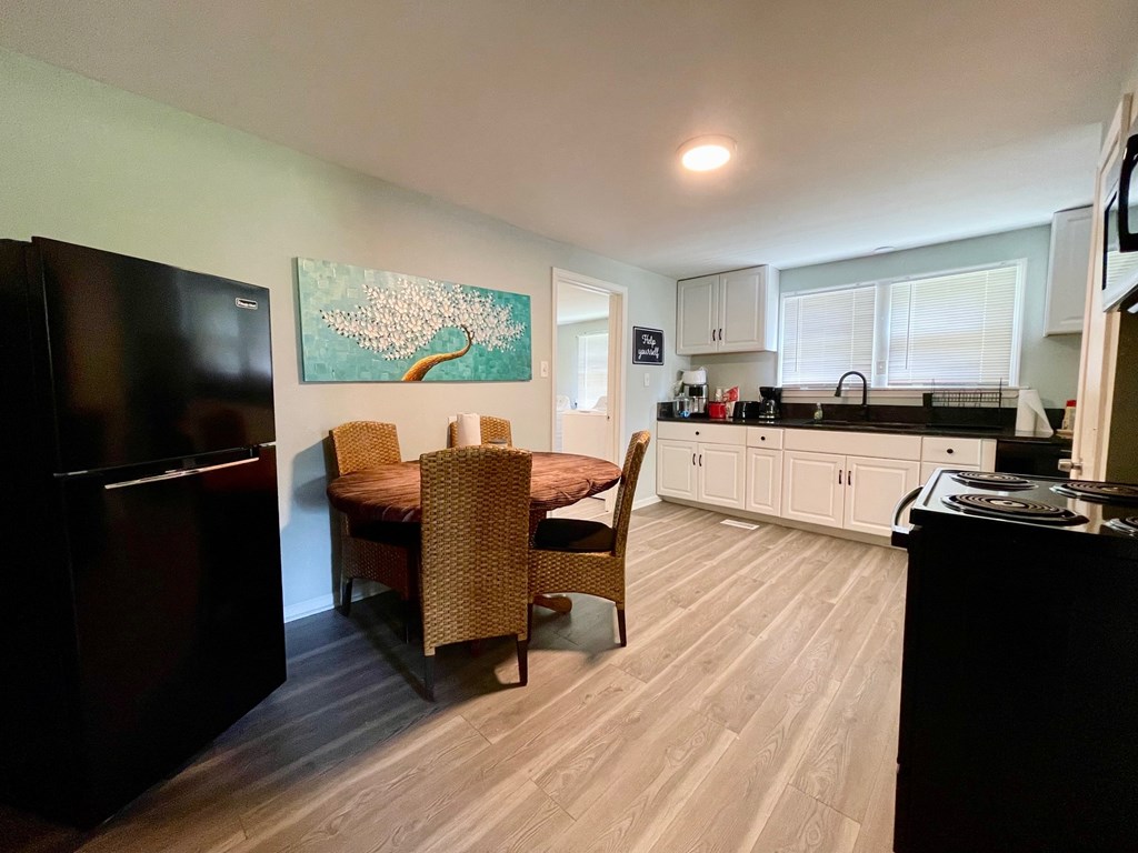 A kitchen with a dining table and chairs.
