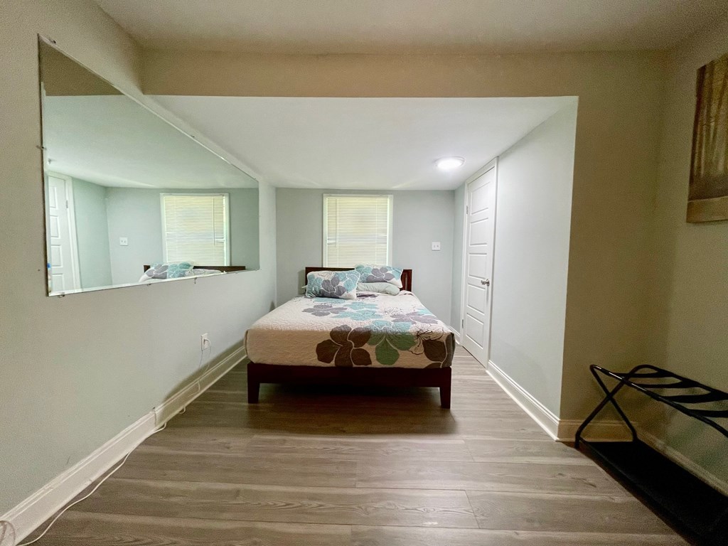 A bedroom with a bed, dresser, and mirror.