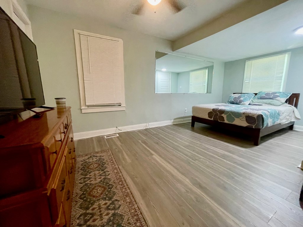 A bedroom with a bed, dresser, and mirror.