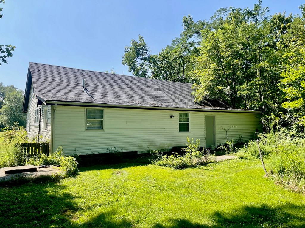A white house with a green door and a small porch.