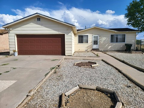 A house with a garage and a gravel driveway.