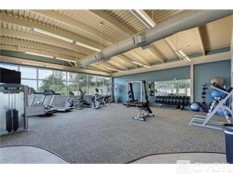 A gym with a variety of equipment including treadmills, weights, and exercise machines.