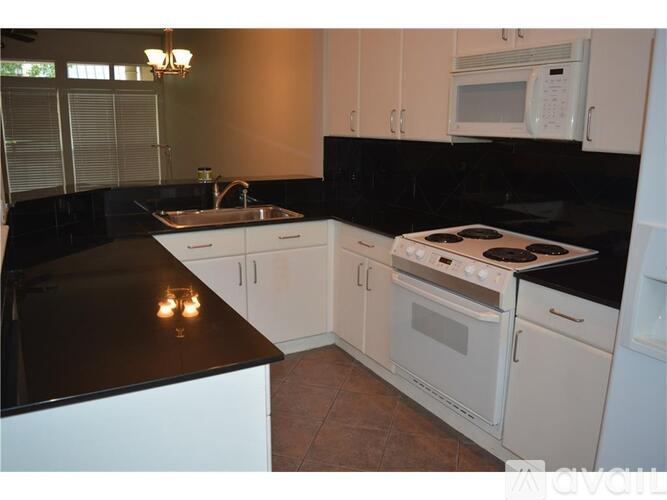 A kitchen with black countertops and white cabinets.