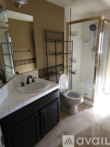 A bathroom with a sink, toilet and shower.