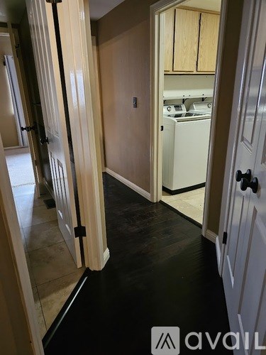 A hallway with a washer and dryer in the kitchen area.