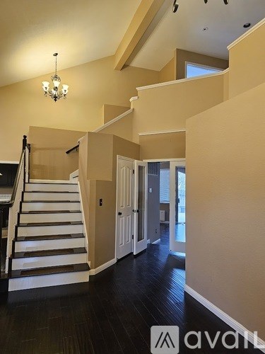 A staircase with a chandelier above it.