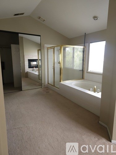 A bathroom with a tub and a mirror.