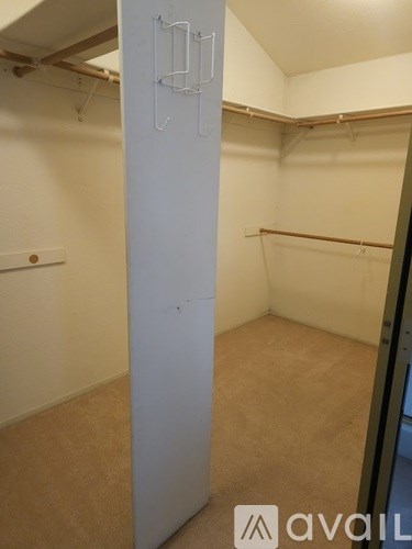 A white closet with a coat hanger on the door.