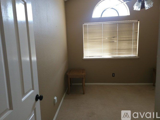 A room with a window, a table, and a door.