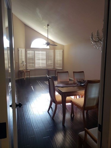 A room with a dining table and chairs.