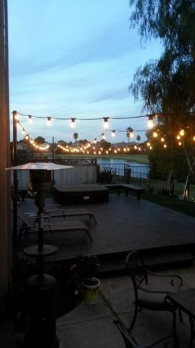 A patio with a table and chairs overlooking a body of water.