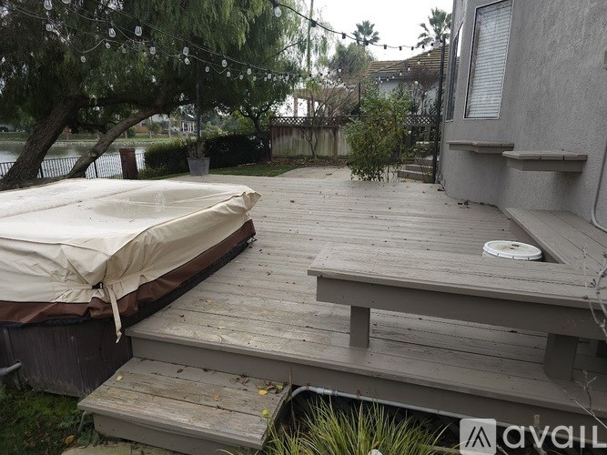 A boat is covered and stored on a wooden deck.
