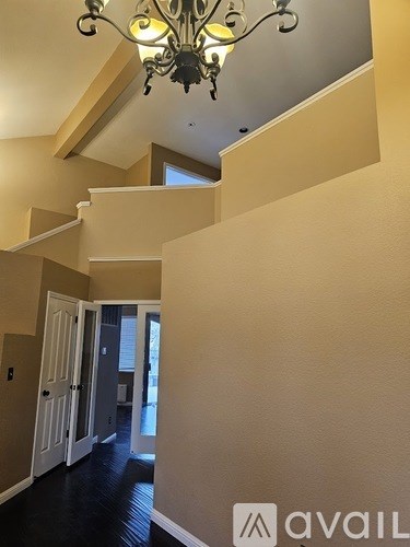 A hallway with a chandelier and a logo that says "avaiL".