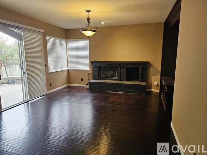 A living room with a fireplace and sliding glass doors.