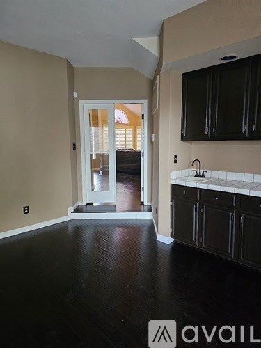 A kitchen with black cabinets and a white sink.