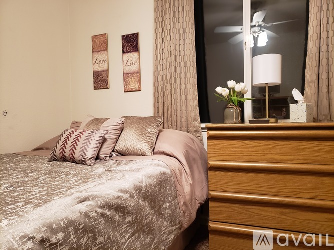 A bedroom with a bed, a dresser, and a mirror.