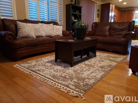 A brown leather couch with a white pillow sits in a living room.