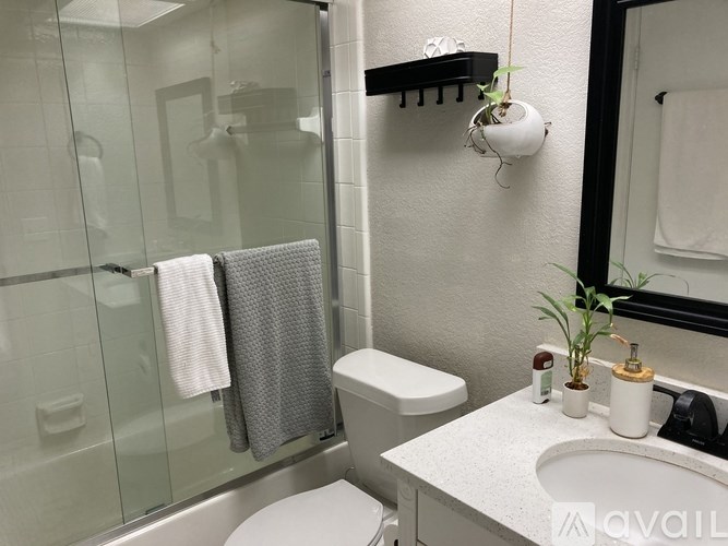 A bathroom with a toilet, sink, and a mirror.