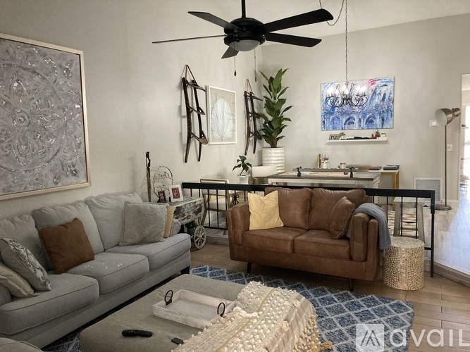 A living room with a grey couch and a brown couch.