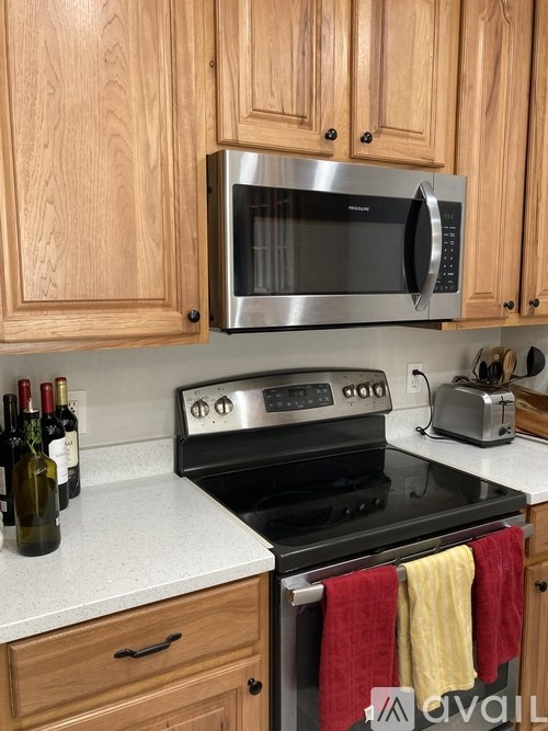 A kitchen with wooden cabinets and a stainless steel oven.