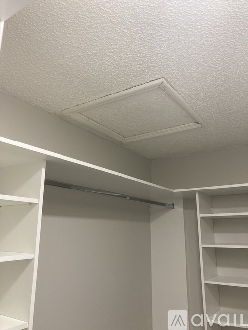 A white closet with shelves and a hanging rod.