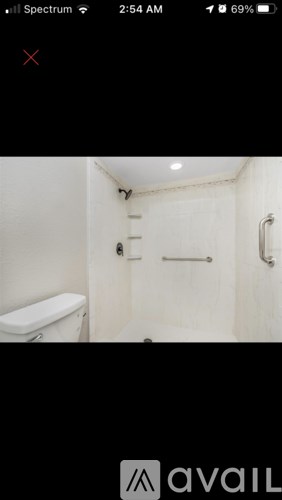 A small bathroom with a toilet, sink, and shower.