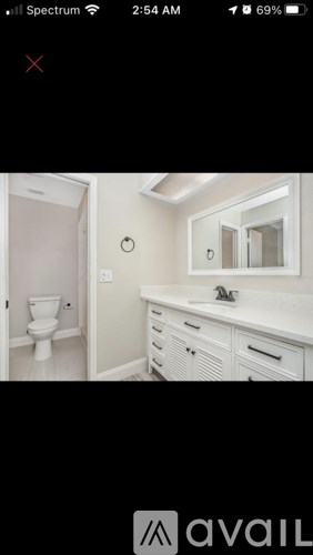 A bathroom with a toilet, sink, and mirror.