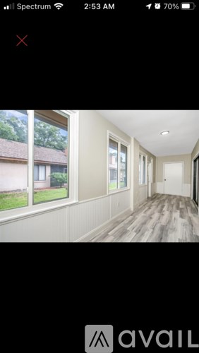 A room with wooden flooring and white walls.