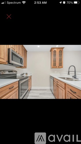 A kitchen with wooden cabinets and a black countertop.