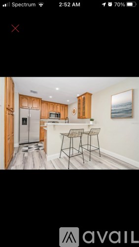 A kitchen with wooden cabinets and a fridge.