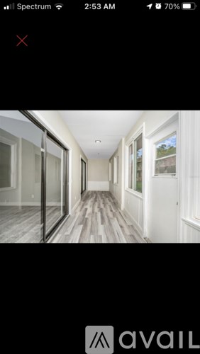 A hallway with wooden floors and white walls.